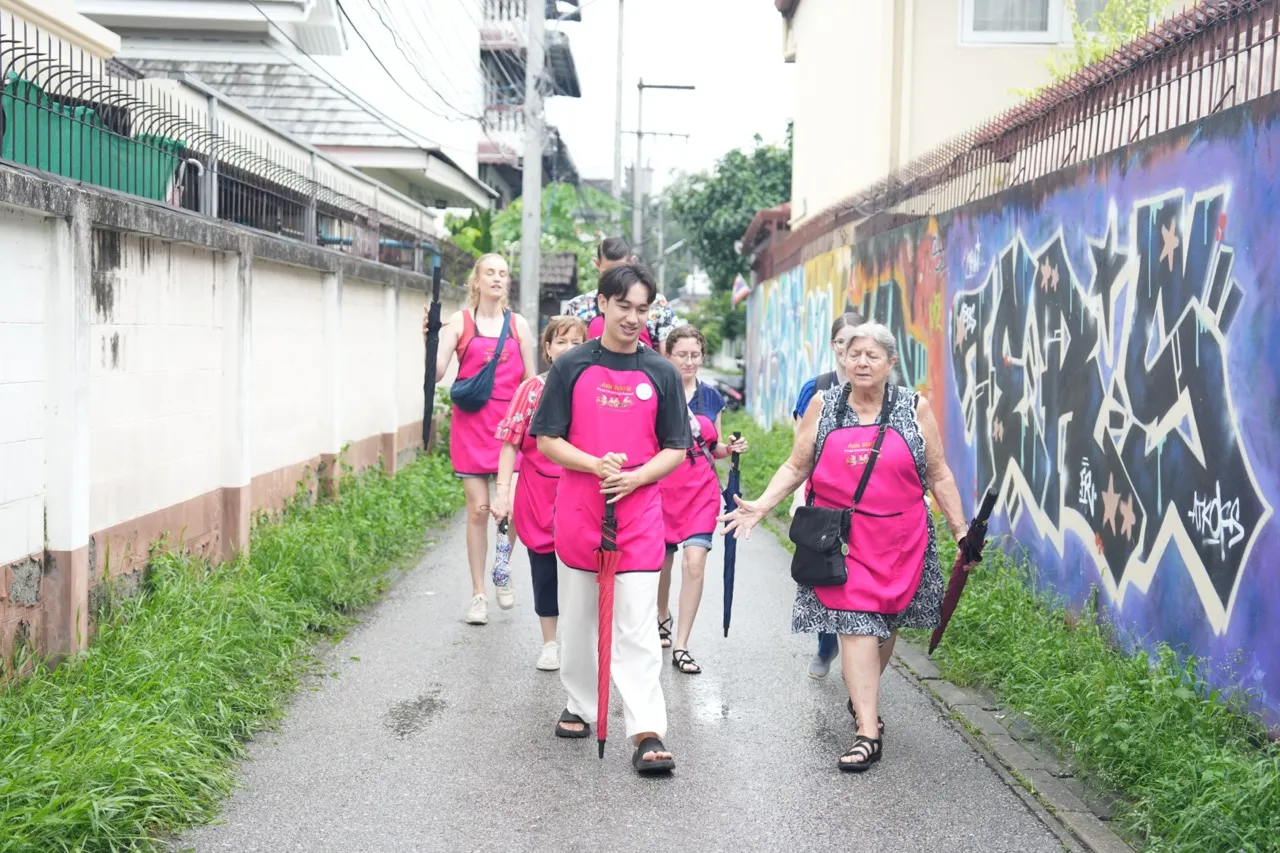 Asia Scenic cooking class guests walking through a local Chiang Mai neighborhood on the way to the fresh market.