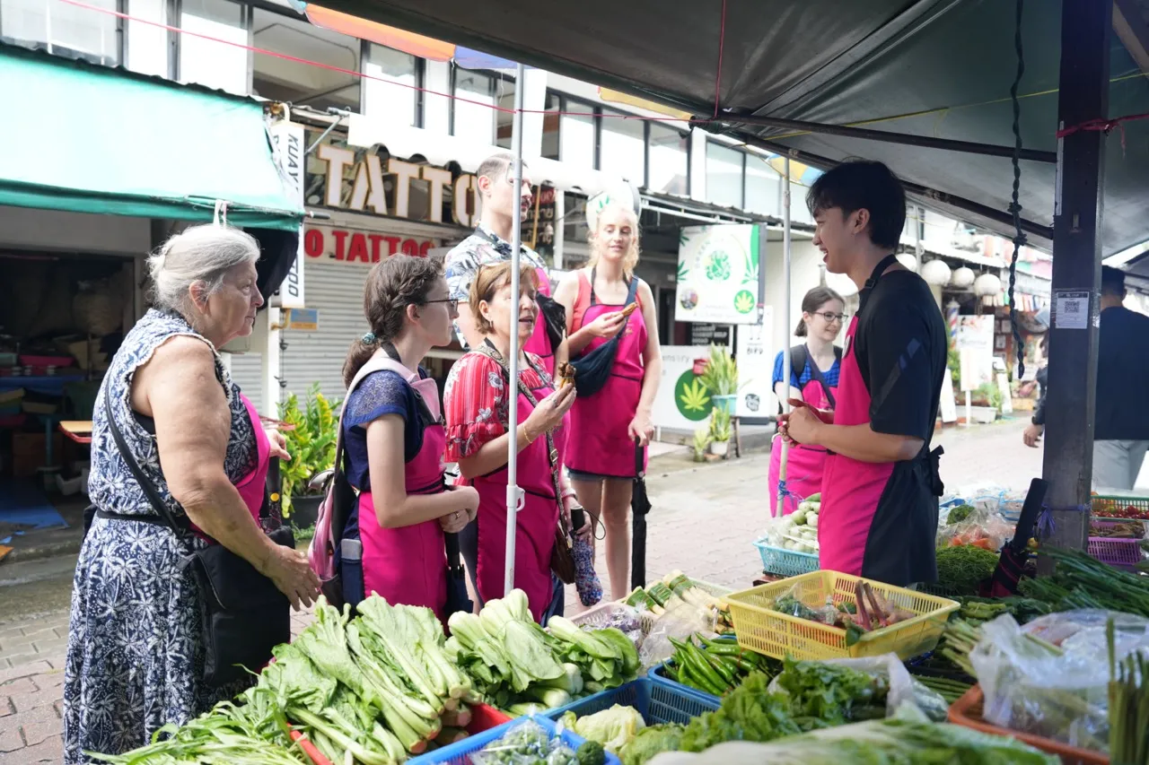 Guests learning about Thai vegetables and local ingredients during a Chiang Mai fresh market tour.